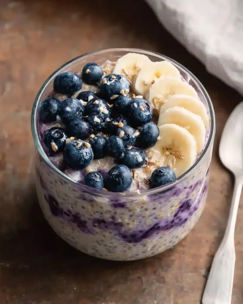 Blueberry Banana Overnight Oats in a jar topped with fresh blueberries and bananas