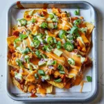Delicious Buffalo Chicken Nachos topped with cheese and garnishes