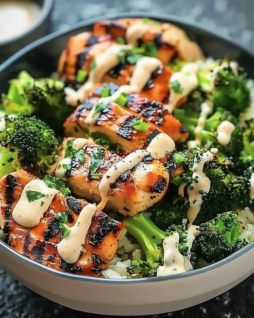 Grilled chicken and broccoli bowls with creamy garlic sauce in a serving dish