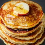 Healthy oatmeal apple pancakes served on a plate with fresh apples