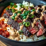 Korean BBQ steak rice bowl garnished with fresh vegetables and sesame seeds