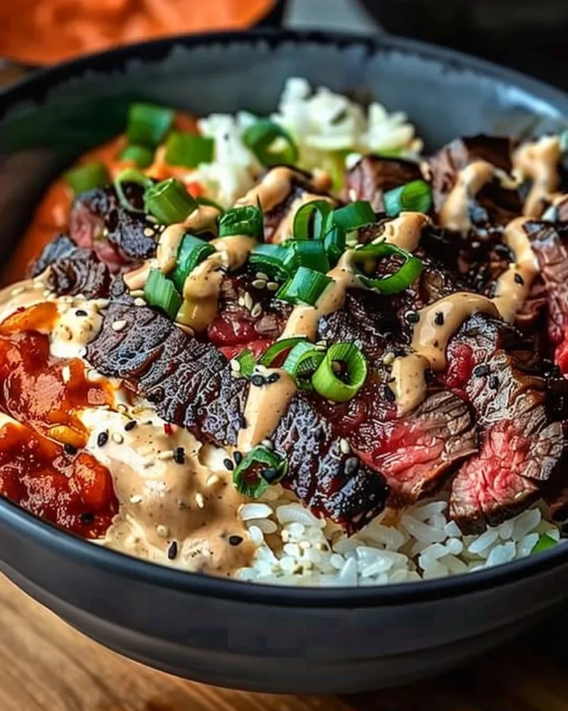 Korean BBQ steak rice bowl garnished with fresh vegetables and sesame seeds