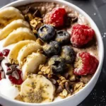 Delicious yogurt bowl topped with fresh fruits and nuts.