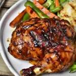 BBQ grilled chicken leg quarters on a serving platter