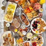 Delicious brunch spread featuring pancakes, avocado toast, and fresh fruits.