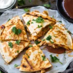Delicious BBQ chicken quesadillas on a plate with melted cheese and fresh toppings