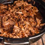 Slow cooker BBQ pulled pork served on a bun with coleslaw